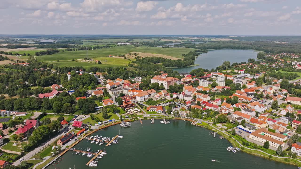 Drone flyver tilbage, med Ryns klare havnefronts grønne områder og fredfyldt udsigt over søen
