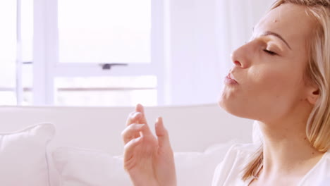 mujer sentada en un sofá comiendo algunas frutas