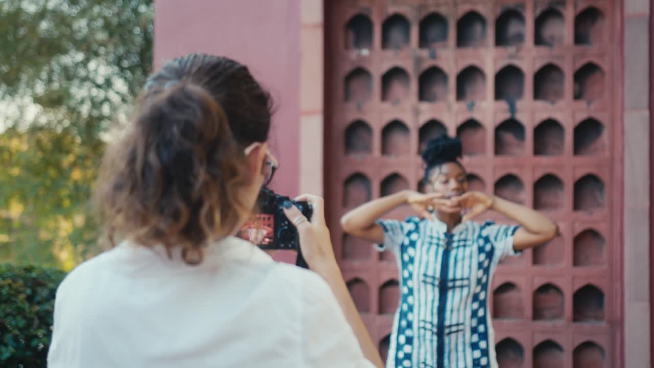 Photographer capturing a photo shoot with a model in front of a historical building