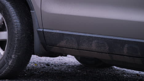 Close-Detail-shot-of-Rain-Drops-on-parked-car-on-dirt-road-in-stormy-weather