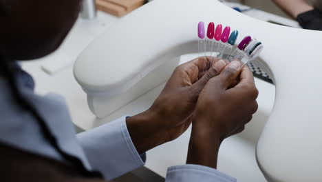 nail technician selecting nail polish colors