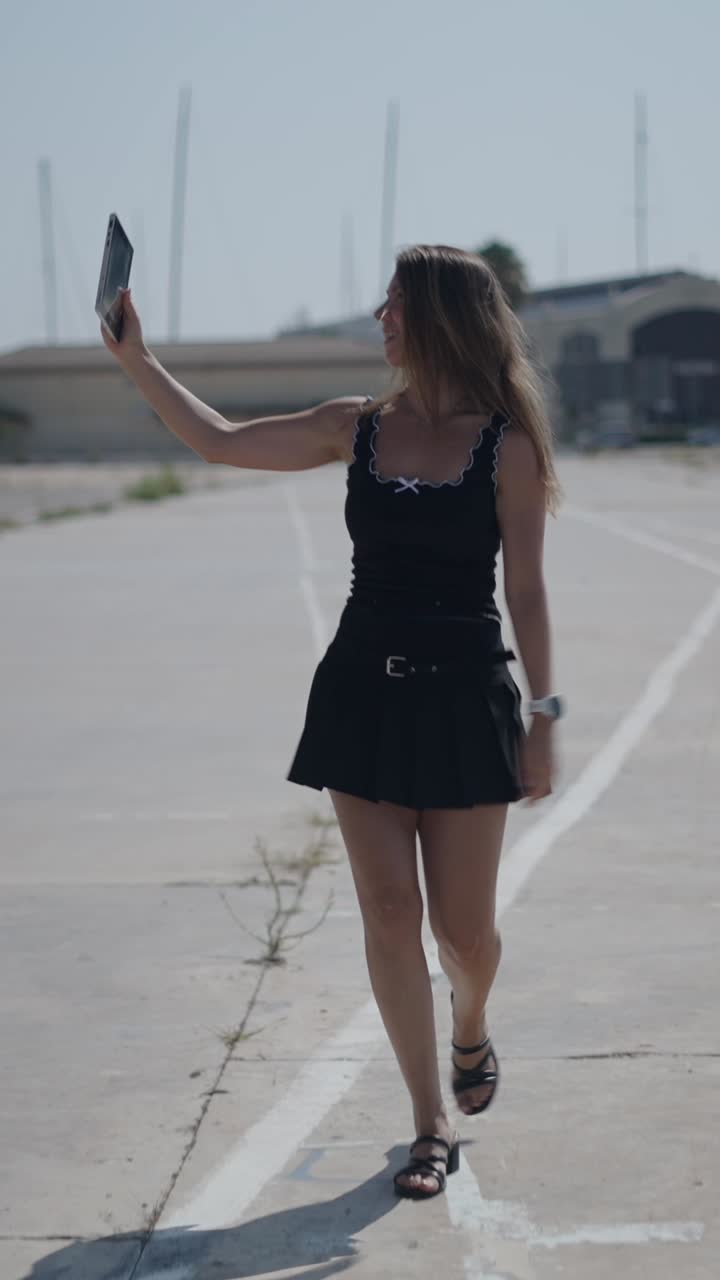 Una donna che cammina e scatta foto con uno smartphone
