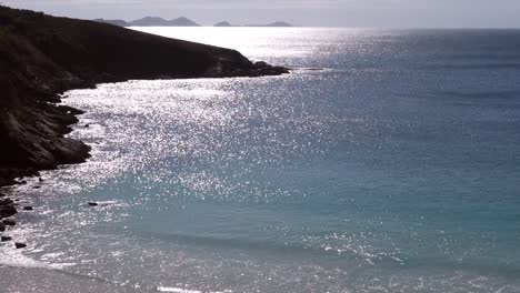 morning sun rays reflecting on sea surface at mountain bay