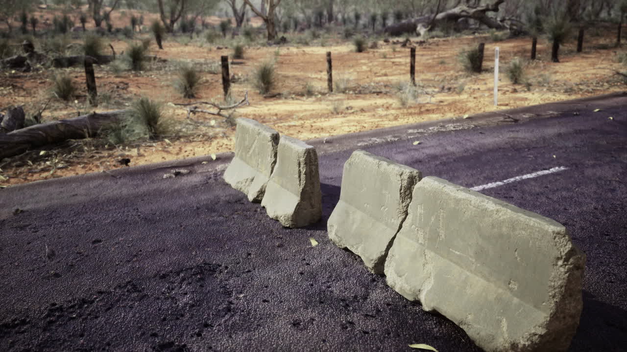 Road barrier shows signs of weathering in an outback landscape during daytime