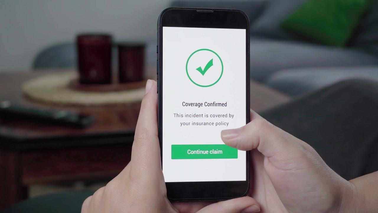 La scritta "Copertura Confermata" appare su un'app di reclamo digitale con un'icona di spunta verde e un pulsante "Continua reclamo" su un dispositivo portatile.