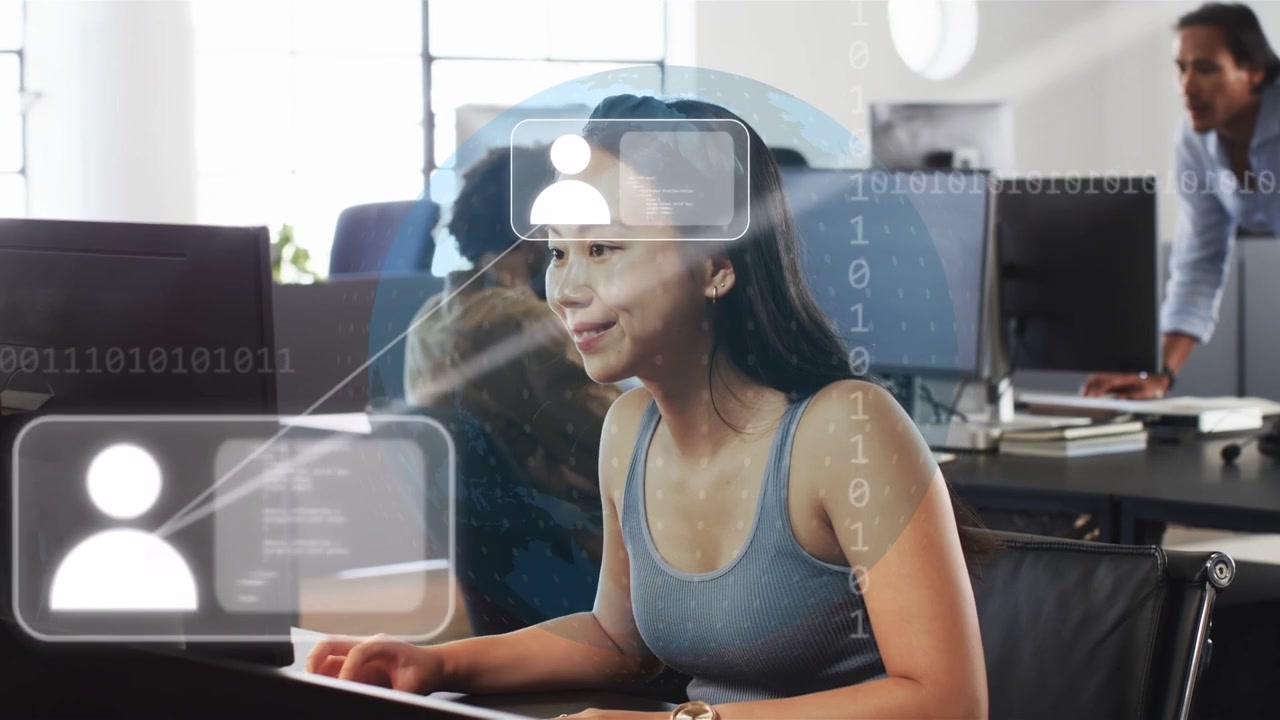 Woman typing at keys in business office, spawning HUD icons and bit stream indicating network alert
