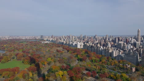 Imágenes-Panorámicas-Aéreas-De-Un-Gran-Parque-Con-árboles-De-Colores-Otoñales-Y-Edificios-Circundantes.-Barrios-Alrededor-Del-Parque-Central.-Manhattan,-Ciudad-De-Nueva-York,-Estados-Unidos