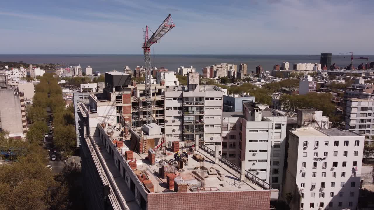 vista aérea del sitio de construcción en bloque con grúa en la ciudad de montevideo, uruguay