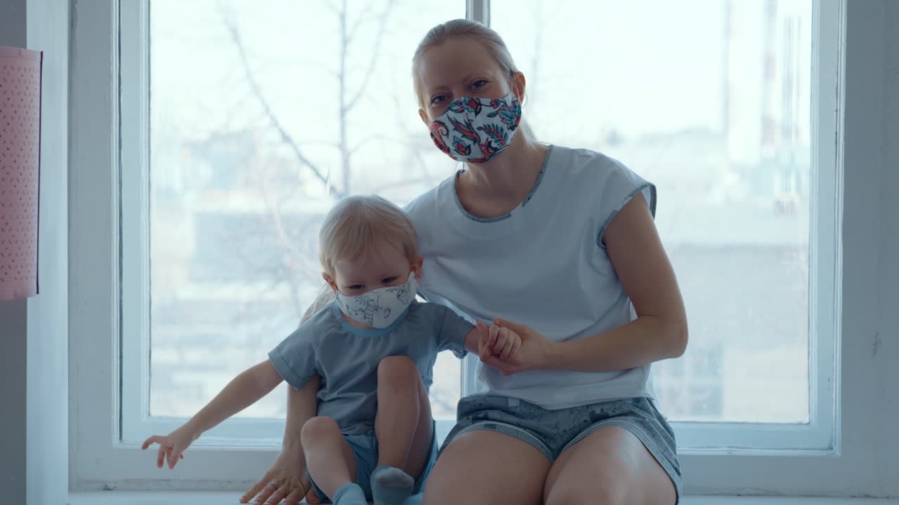 Mother and Child Wearing Masks at Window