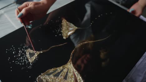 creating abstract resin art with gold leaf