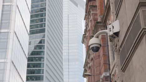 close up of surveillance camera outside modern office buildings in city of london uk