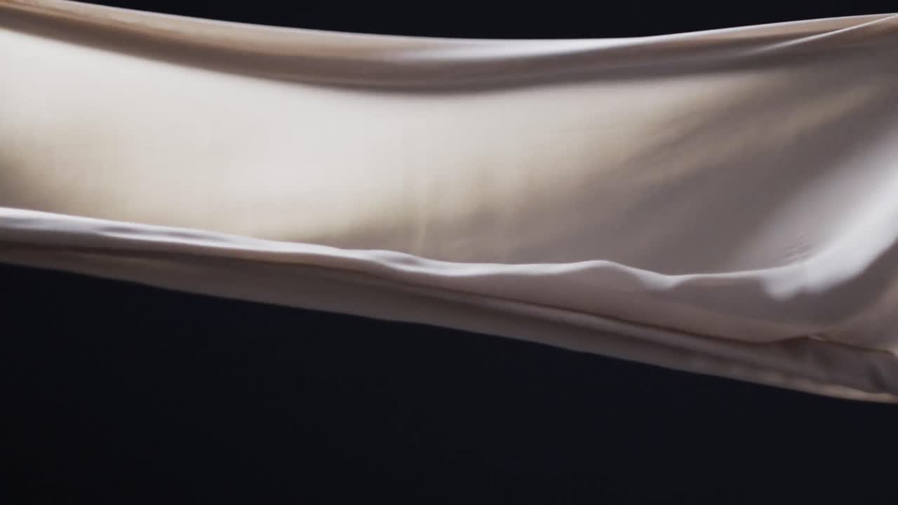 검은색 배경 위에 복사 공간과 함께  ⁇ 색 천을 불어 넣는 애니메이션