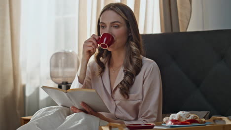 Woman enjoying coffee and reading in bed