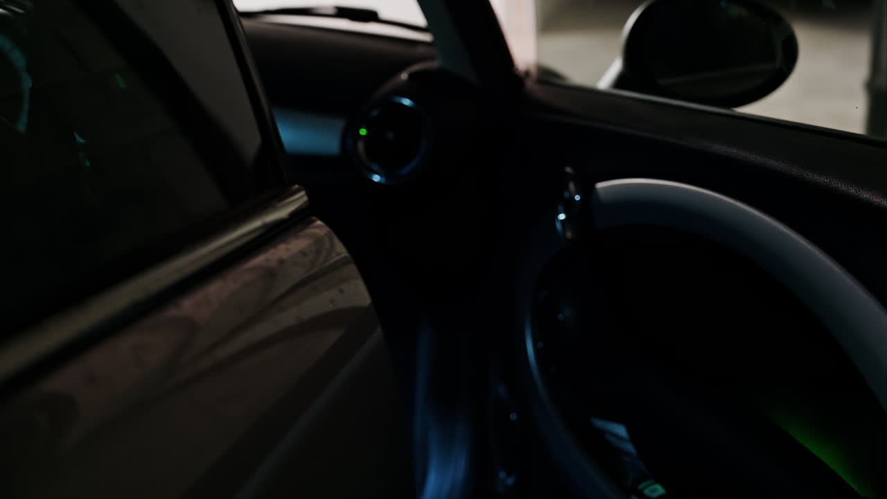 Close up of a woman's hand opening and closing the car door in a parking lot