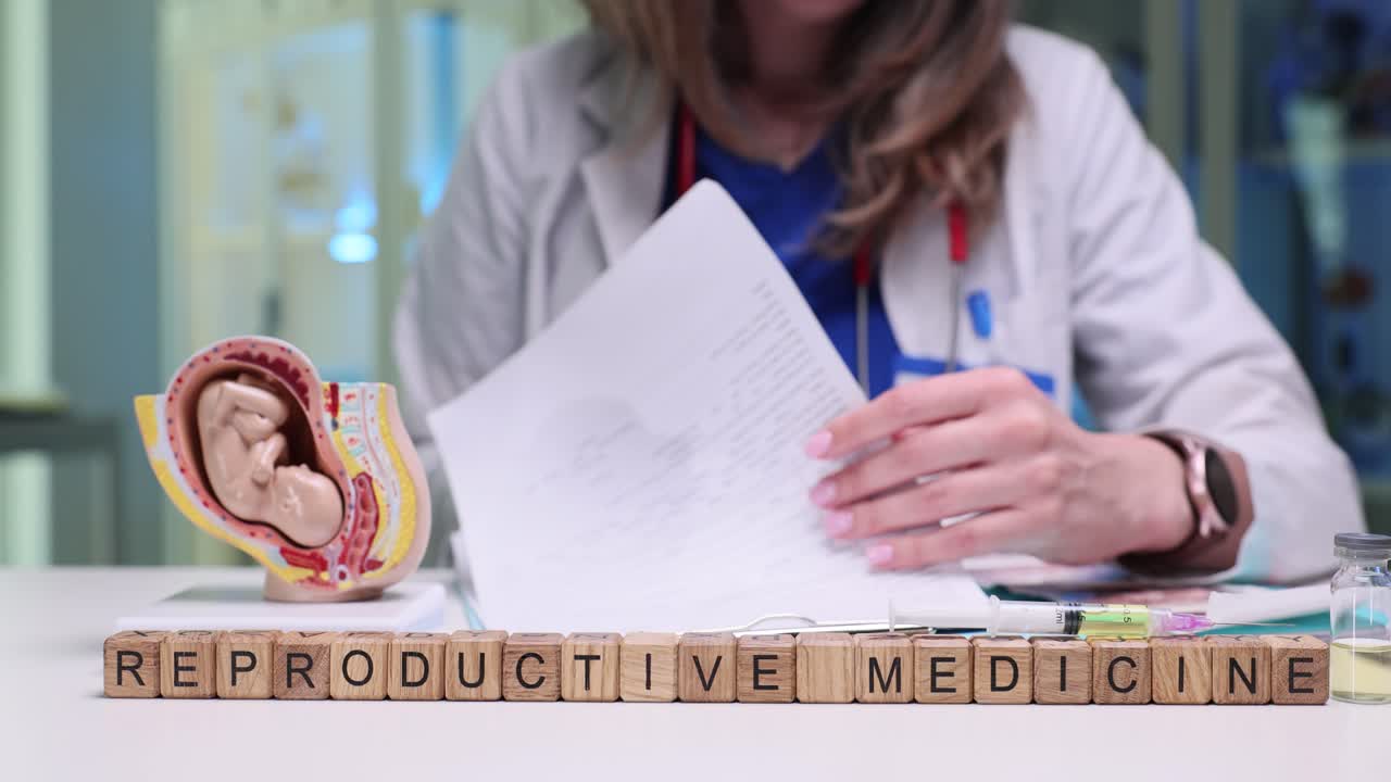 Médico trabajando con materiales de medicina reproductiva y modelo de feto