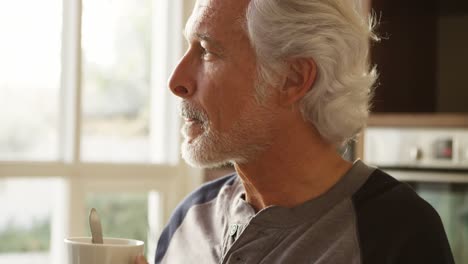 Senior-man-having-coffee-in-kitchen-at-home-4k