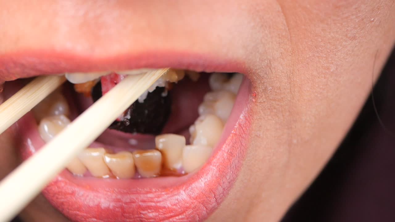 Person eating sushi with chopsticks