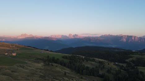 aerial drone shot of the alps while sunset with huts and farmland, beautiful nature