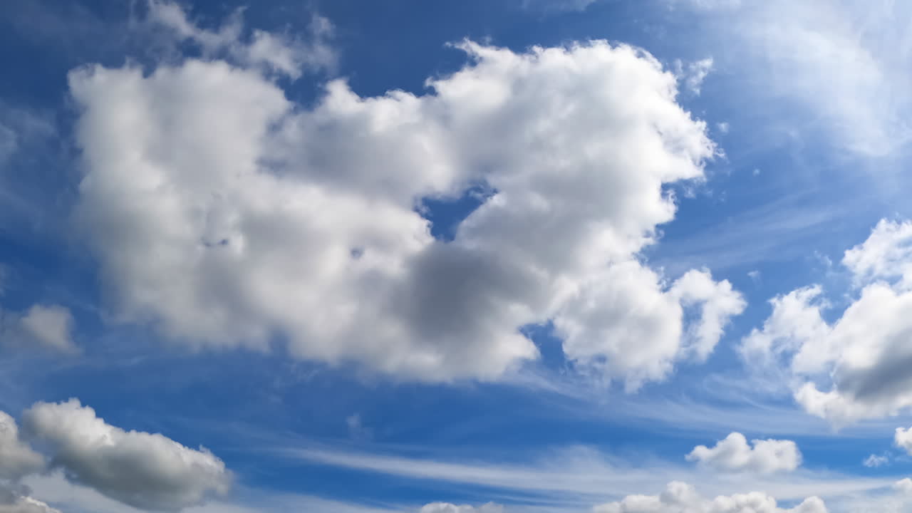 White fluffy clouds growing and disappearing in the sky. Low angle view on the cloudscape transformation in the atmosphere. Timelapse.