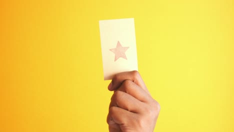 hand holding a card with a star