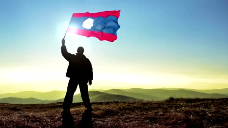 successful silhouette man winner waving laos flag on top of the mountain peak, cinemagraph loop background