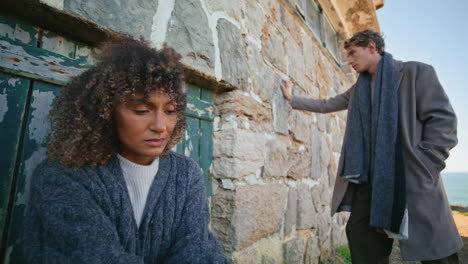 breakup couple feeling sad at chateau near ocean. models posing abandoned place