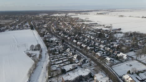 aerial of small rural town surrounded by snow covered meadows