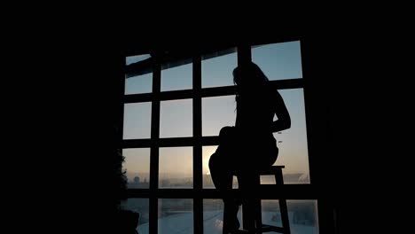 silhouette-of-lady-sitting-and-dancing-on-stool-at-sunset