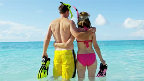 caucasian couple going snorkeling on luxury beach vacation