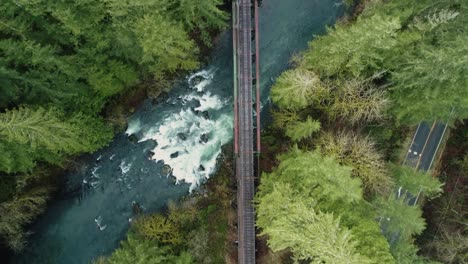 slow overflight above railroad tracks crosses river and through trees