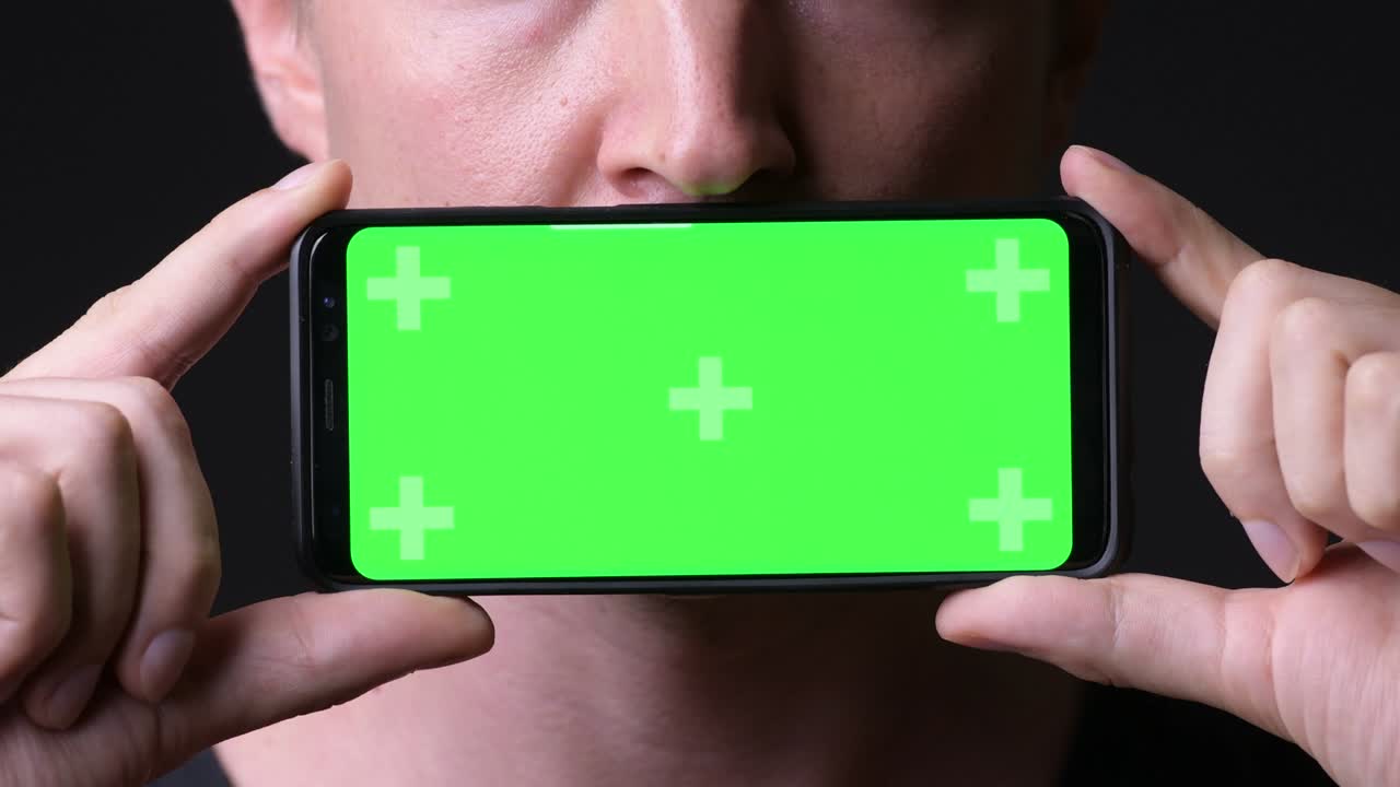 크로마 키 녹색 화면 을 가진 휴대 전화 를 들고 있는 남자