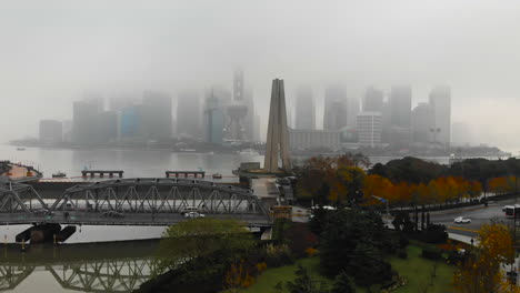 Dron-Ascendente-Que-Revela-El-Monumento-A-Los-Héroes-Del-Pueblo-De-Shanghai,-El-Puente-Waibaidu,-El-Río-Huangpu