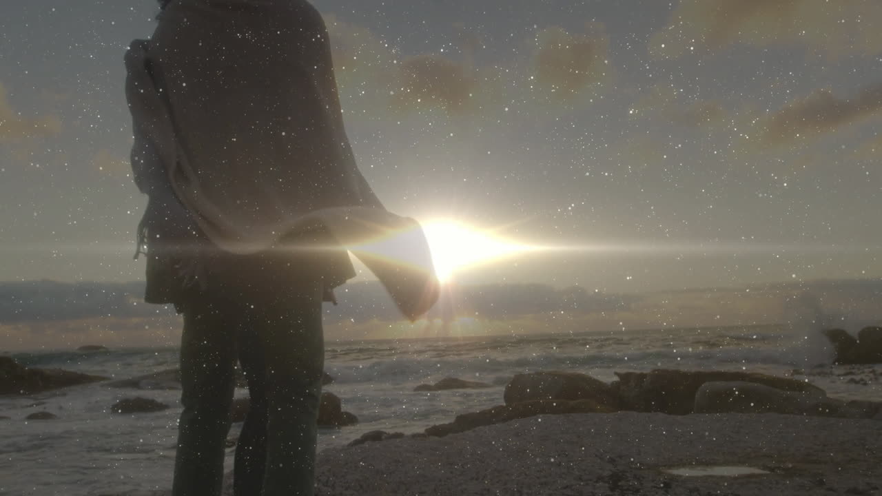 couple standing on rocky shoreline sunset, showing star overlay enhancing technology digital design