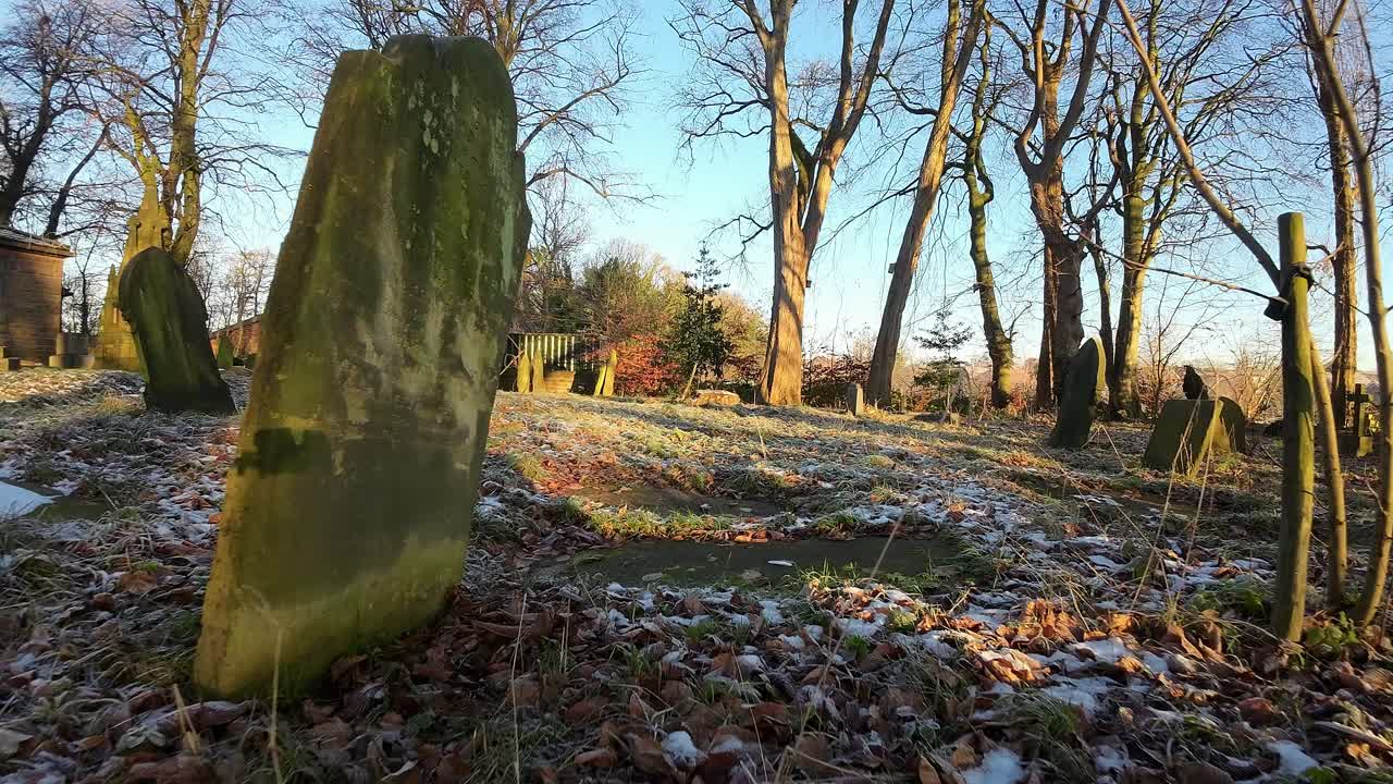 fpv volando alrededor de lápidas en otoño amanecer nevado cementerio cementerio durante la hora dorada