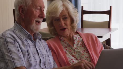 Senior-couple-in-social-distancing-using-laptop