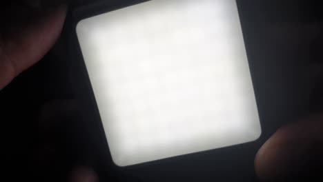 switching on a small but blinding diffused video light with led emitters inside and off again