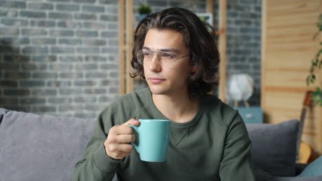 young man relaxing at home with coffee