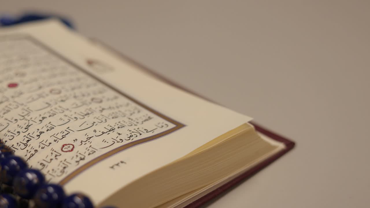 imágenes de un corán tendido en una mesa con un tasbeeh, las cuentas de oración, en ella, el tiro se mueve de derecha a izquierda en medio círculo