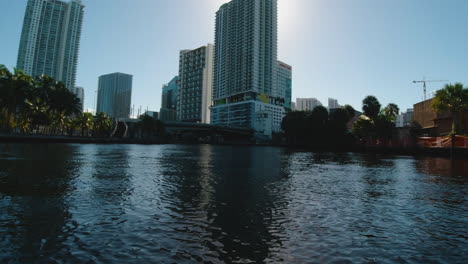 view from a small boat on the canals of miami waterways as it approaches tall buildings