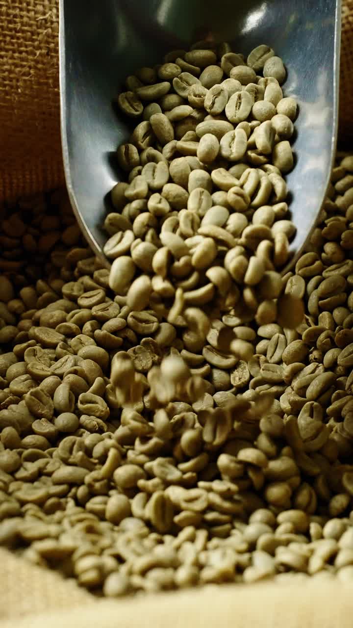 Primo piano di chicchi di caffè verde che cadono da un misurino di metallo