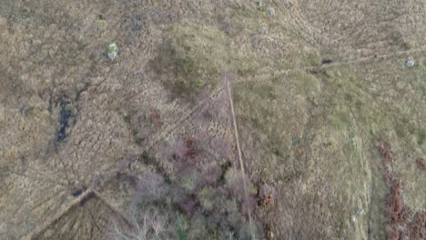 imágenes de drones aéreos que vuelan sobre los campos y un camino remoto de una sola vía, inclinándose lentamente para revelar glen etive y loch etive en las tierras altas de escocia con montañas nevadas y un bosque