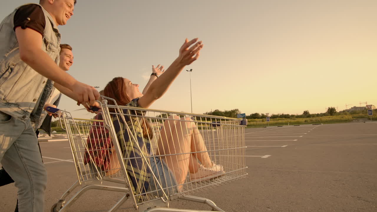 amigos jóvenes divirtiéndose en un carrito de compras. jóvenes multiétnicos jugando con el carrito de tiendas