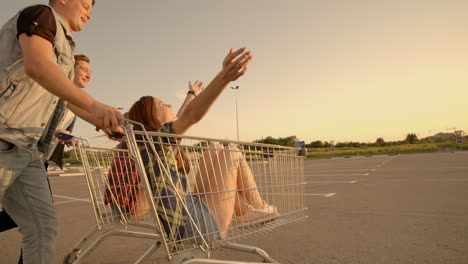 young friends having fun on a shopping carts. multiethnic young people playing with shopping cart