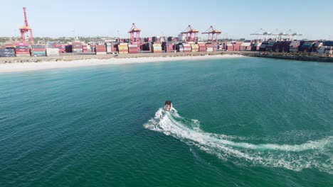 Una-Toma-Aérea-De-Un-Adolescente-Esquivando-Detrás-De-Una-Lancha-Rápida-En-El-Puerto-De-Fremantle