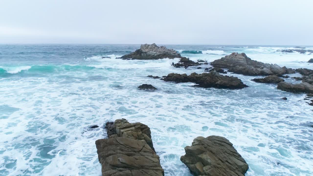 Spiaggia rocciosa di Monterey, California, con onde che si infrangono, vista aerea che si avvicina a un nido d'uccelli