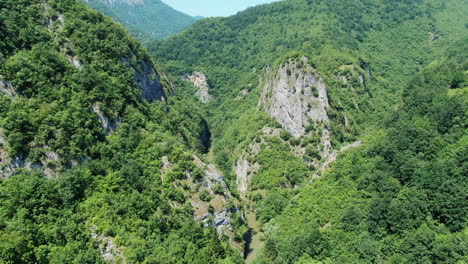 aerial view of a river valley surrounded by steep tree covered hills creating a natural and scenic landscape