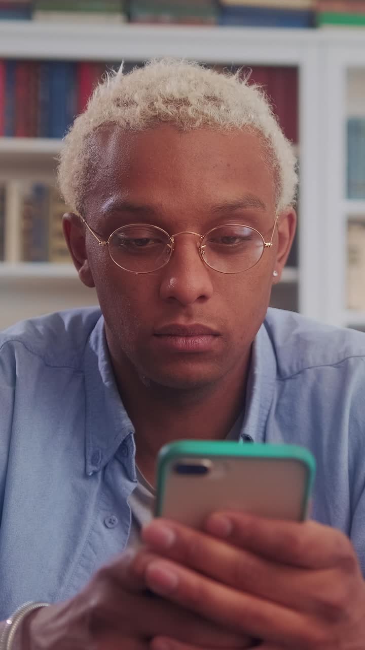 Focused young man engaged with his phone in a cozy setting