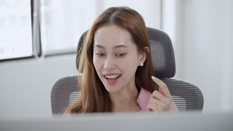 a woman joyfully participates in remote work showcasing her engagement and positivity in a bright office.
