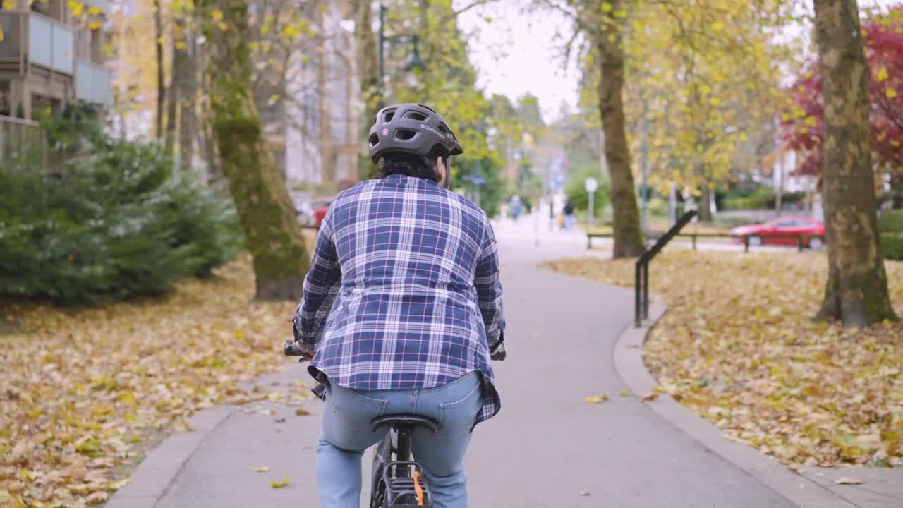 a cyclist leisurely strolls in a park
