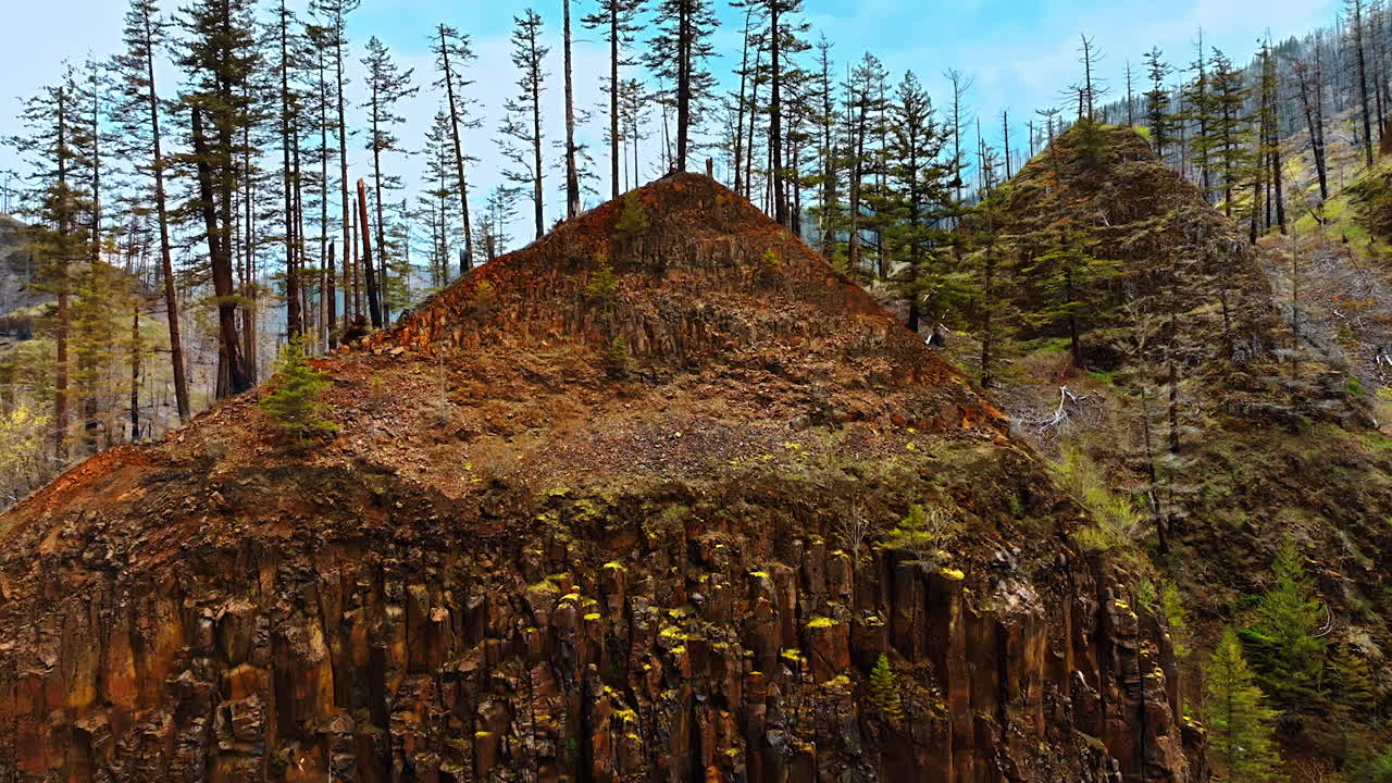 Bare rocky triangular mountains covered with sparse pine trees. Mountainous area in Oregon State, the USA. Top view.